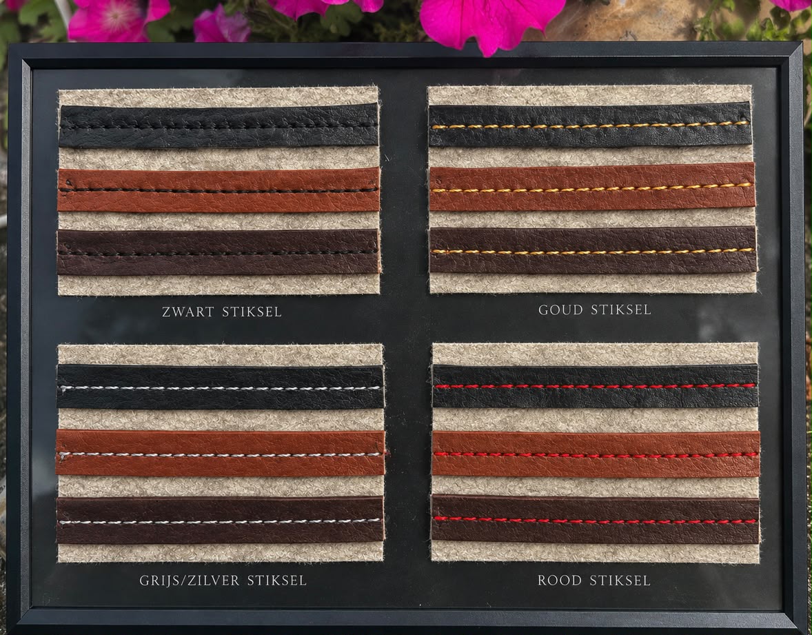 Leren bandjes in zwart, cognac en donkerbruin, afgewerkt met stiksel in zwart, goud, grijs/zilver en rood, op wolvilt